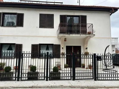a white house with a black fence at Jordan Apartman in Niška Banja