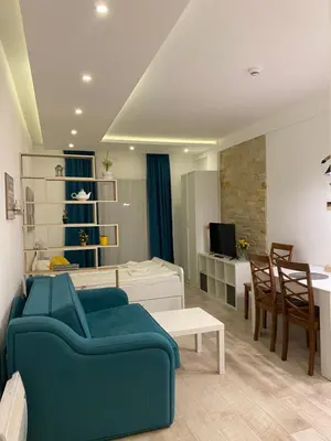 a living room with a blue couch and a table at Snežna pahuljica P19 in Kopaonik