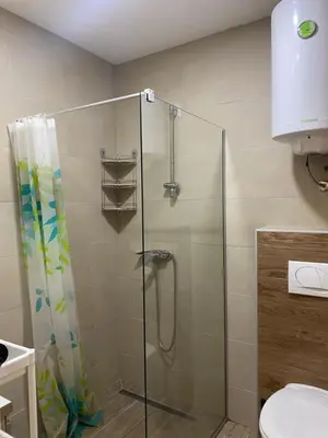 a shower with a glass door in a bathroom at Snežna pahuljica P19 in Kopaonik