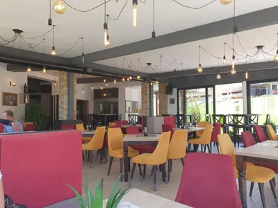 a dining room with tables and chairs and windows at Snežna pahuljica P19 in Kopaonik