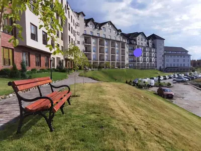 a park bench sitting in the grass in front of a building at Snežna pahuljica P19 in Kopaonik