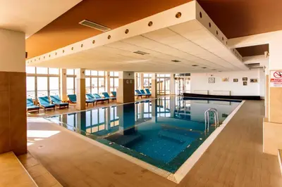 an indoor pool with blue water in a building at Snežna pahuljica P19 in Kopaonik