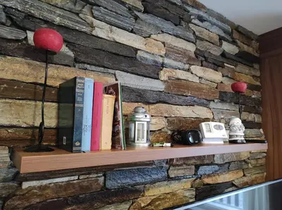 a brick wall with a shelf with books at Apartment Panorama 3 in Kopaonik