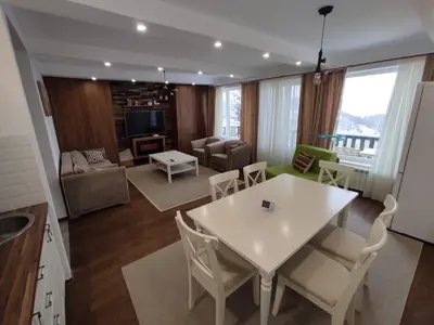 a kitchen and living room with a white table and chairs at Apartment Panorama 3 in Kopaonik