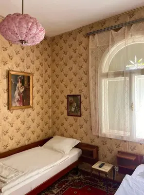 a small bedroom with a bed and a window at Apartment Milinkovic in Niška Banja