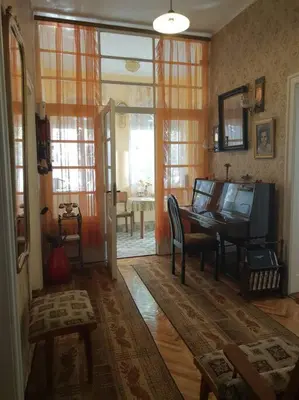 a living room with a desk and a table with a television at Apartment Milinkovic in Niška Banja