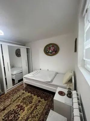 a white room with a bed and a mirror at Apartment Milinković 2 in Kovanluk