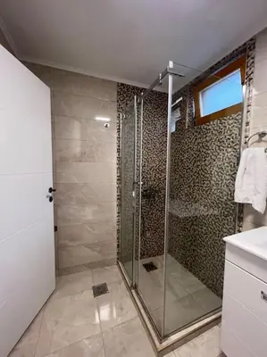 a bathroom with a shower with a glass door at Apartment Milinković 2 in Kovanluk