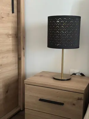 a lamp sitting on top of a wooden dresser at Lilyy lux in Leskovac