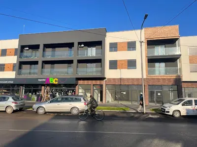 a person riding a bike in front of a building at Lilyy lux in Leskovac