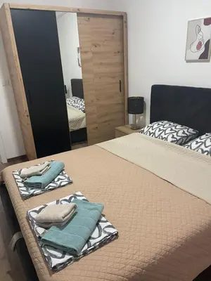 a bedroom with two beds and a mirror at Lilyy lux in Leskovac