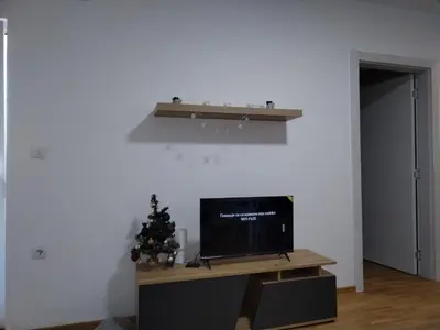 a living room with a television and a christmas tree at S&B Apartman Vrnjačka Banja in Vrnjačka Banja