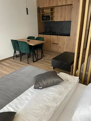 a bed in a room with a table and chairs at Grand Apartman Kopaonik in Kopaonik