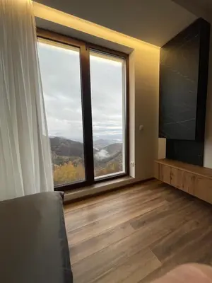 a room with a large window and a television at Grand Apartman Kopaonik in Kopaonik
