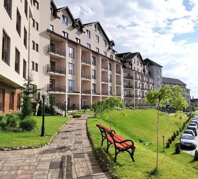 a red park bench in front of a building at TopView Milmari N87 in Kopaonik