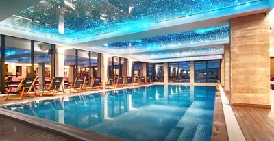 a hotel pool with chairs and a star ceiling at TopView Milmari N87 in Kopaonik