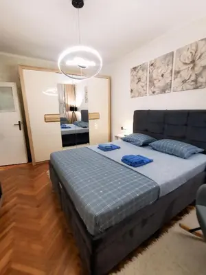 a bedroom with a bed with blue pillows on it at Apartman Aki in Pirot
