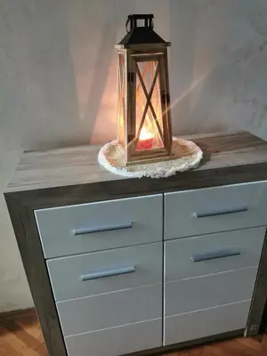 a table with a lantern on top of a dresser at Apartman Aki in Pirot