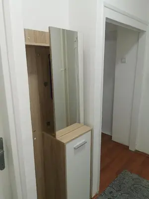 a room with a mirror and a dresser with a closet at Apartman Aki in Pirot