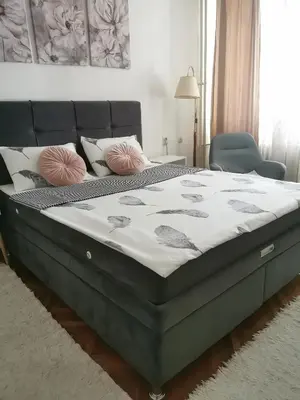 a bedroom with a large bed with pink pillows at Apartman Aki in Pirot
