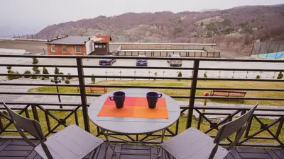 a table and chairs on a balcony with a view at Milmari Apartman Lucky L03 in Kopaonik