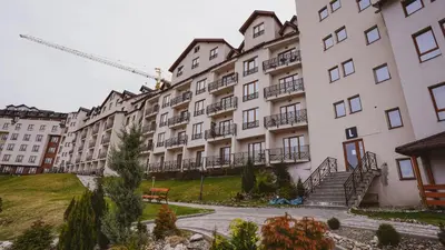 a row of tall white buildings with a park at Milmari Apartman Lucky L03 in Kopaonik