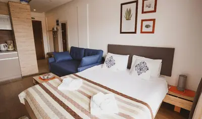 a bedroom with a bed and a blue couch at Milmari Apartman Lucky L03 in Kopaonik