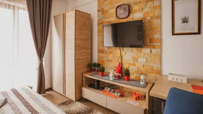 a room with a tv on a brick wall at Milmari Apartman Lucky L03 in Kopaonik