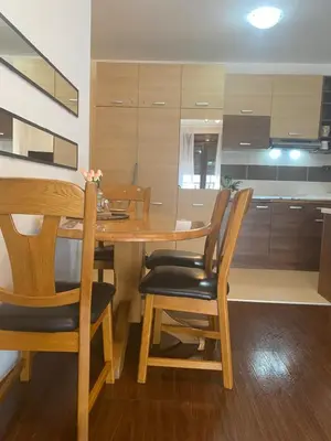 a kitchen and dining room with a wooden table and chairs at Jolly Kop PetkoSKI Apartman in Kopaonik