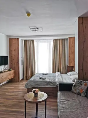 a bedroom with a bed and a couch and a table at Kopaonik apartment A05 in Kopaonik