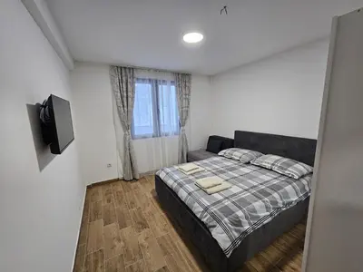 a bedroom with a bed and a flat screen tv at Apartman Stoiljković in Kopaonik