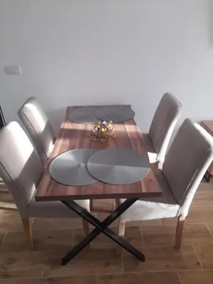 a wooden table with four chairs around it at Apartman Stoiljković in Kopaonik