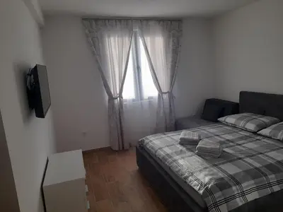 a bedroom with a bed and a television and a window at Apartman Stoiljković in Kopaonik