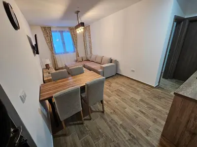 a living room with a table and chairs and a couch at Apartman Stoiljković in Kopaonik