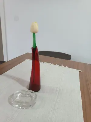 a vase with a flower in it sitting on a table at Apartman MASTER Porta Infinitas in Vrnjačka Banja