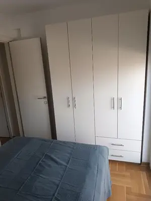 a bedroom with white cabinets and a bed at Apartman MASTER Porta Infinitas in Vrnjačka Banja