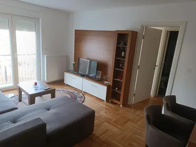 a living room with a couch and a tv at Apartman MASTER Porta Infinitas in Vrnjačka Banja