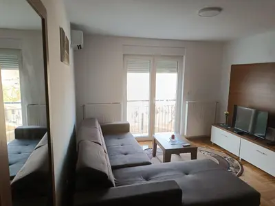 a living room with a couch and a television at Apartman MASTER Porta Infinitas in Vrnjačka Banja