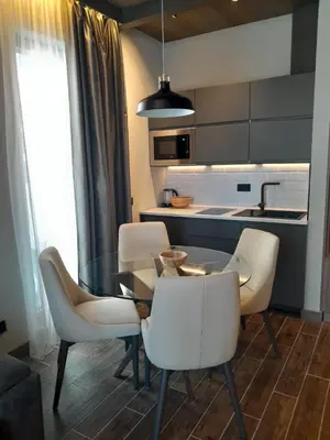 a kitchen with a glass table and white chairs at Stefany in Kopaonik