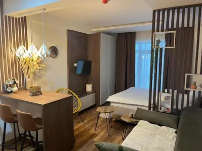 a bedroom with a bed and a living room at Apartman Košuta-Prezident in Kopaonik