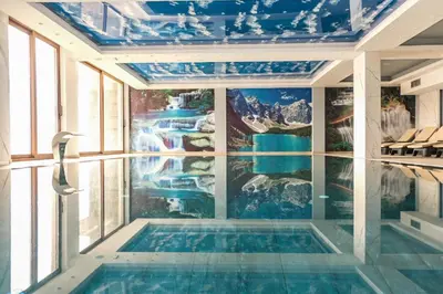 a swimming pool in a room with a waterfall mural at Apartman Košuta-Prezident in Kopaonik