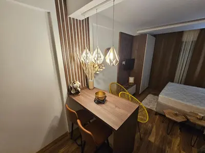 a room with a table and chairs and a bed at Apartman Košuta-Prezident in Kopaonik
