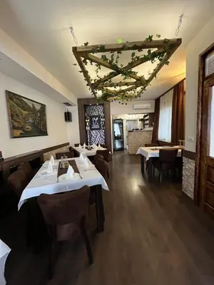 a restaurant with tables and chairs in a room at 9 mezeta in Pirot