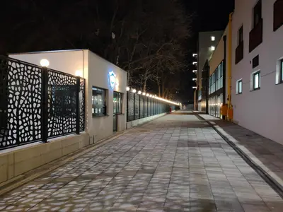 an empty street at night with lights on at Boho style in Jagodina
