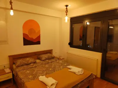 a small bedroom with two beds and a window at Boho style in Jagodina