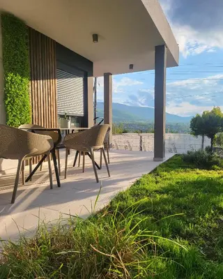 a patio with chairs and a table with a view at Duos West in Soko Banja