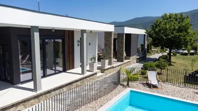 a villa with a swimming pool and a house at Duos West in Soko Banja