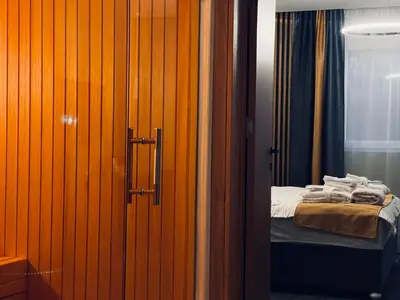 a bedroom with a bed and a door with towels at MOZAIK APARTMENTS & SPA - Modern 4-Star Apartments with Exclusive Private SPA WELLNESS in the City Center - SAUNA, JACUZZI, TURKISH BATH - FREE PARKING, Wi-FI - Rooms & Apartments Cuprija in Ćuprija
