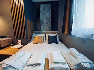 a large bed with towels on it in a room at MOZAIK APARTMENTS & SPA - Modern 4-Star Apartments with Exclusive Private SPA WELLNESS in the City Center - SAUNA, JACUZZI, TURKISH BATH - FREE PARKING, Wi-FI - Rooms & Apartments Cuprija in Ćuprija