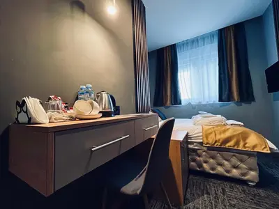 a bedroom with a bed and a dresser with a mirror at MOZAIK APARTMENTS & SPA - Modern 4-Star Apartments with Exclusive Private SPA WELLNESS in the City Center - SAUNA, JACUZZI, TURKISH BATH - FREE PARKING, Wi-FI - Rooms & Apartments Cuprija in Ćuprija
